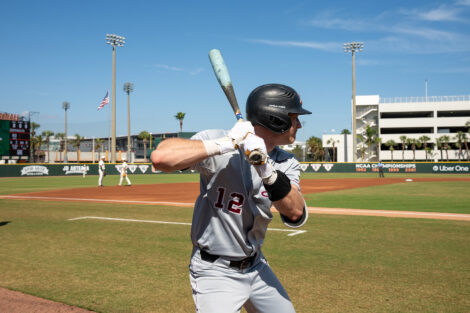 A member of the Lafayette baseball team is at home plate and holding a baseball bat. His jersey reads number 12.