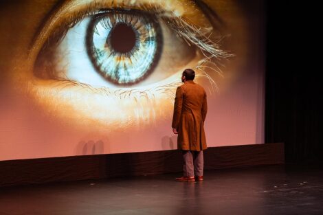 A person looks at a projection of an eye on stage