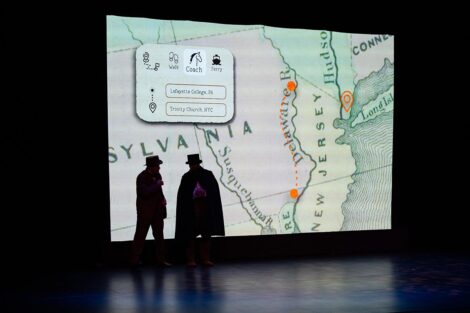 Two men on stage in front of a projected map