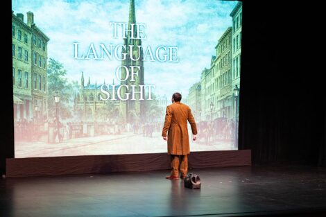 Man on stage in front of projection that says The Language of Sight
