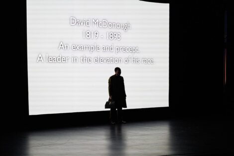 Man on stage in front of projection