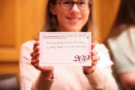 An attendee holds up a postcard that says 