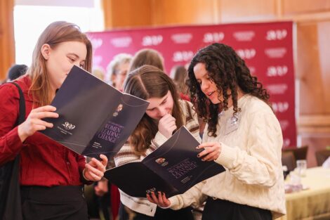 Three attendees gather over the conference program
