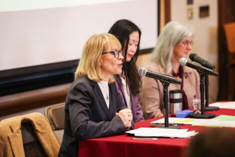 Panelists speak into a microphone at the Conference