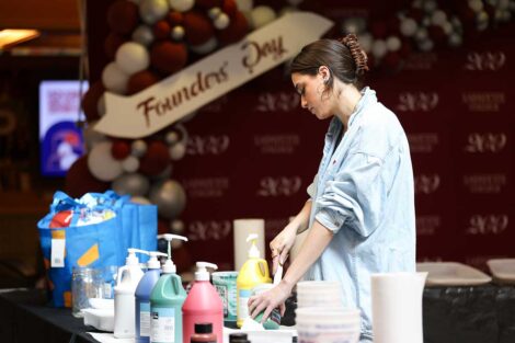 Izzy Sorrells '23 laying out paints on table in Farinon College Center for Founders' Week mural project