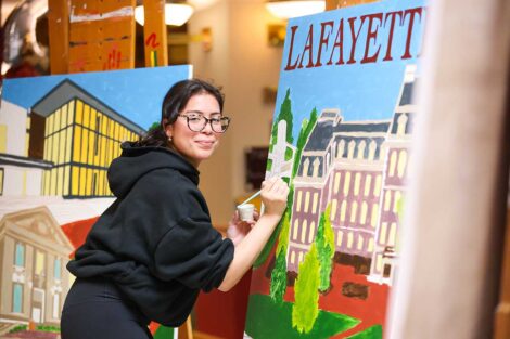 Student painting the Founders' Week mural
