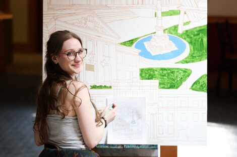 Student painting the Founders' Week mural