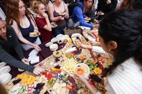 Students grab from a grazing table with 200 designed on it