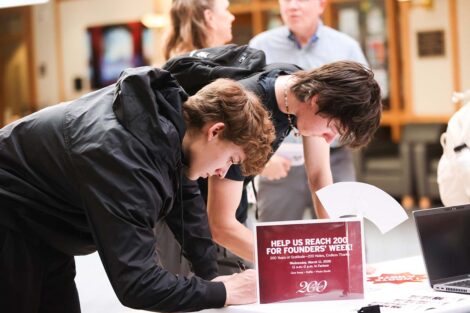 Two students write notes