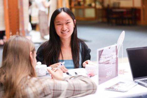 A person writing a note smiles