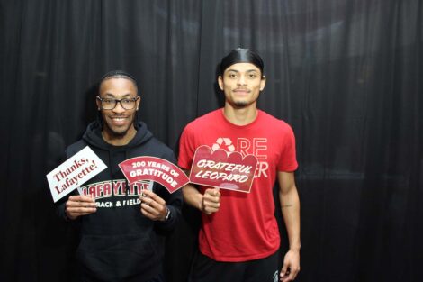 Students pose with signs that say grateful Leopard in the photobooth