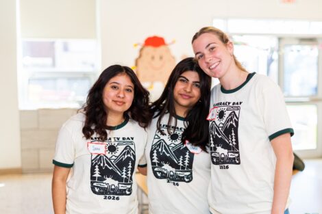 Three Lafayette students wearing Literacy Day T-shirts embrace at the event.