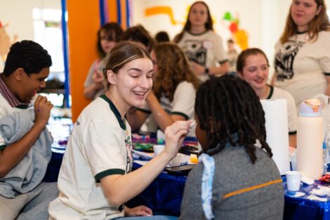 A Lafayette student paints an EASD student's face during Literacy Day as others look on.