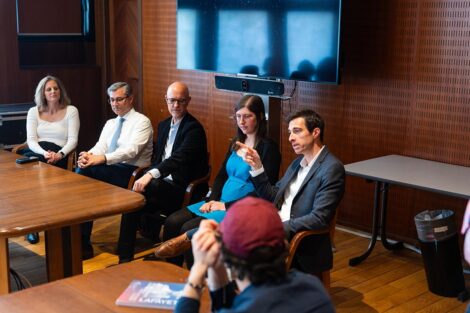 Panelists sit around a table for discussion