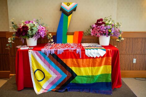 A table with a Pride flag at Lavender Celebration