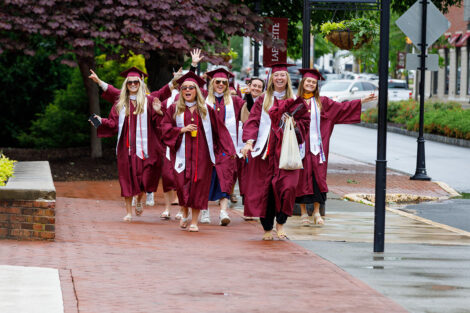 Graduates smile on their way to Commencement