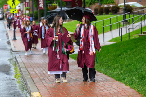 Graduates smile on their way to Commencement