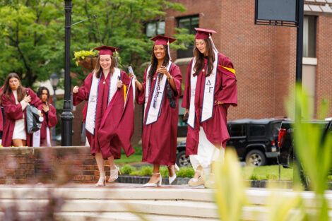 Graduates smile on their way to Commencement