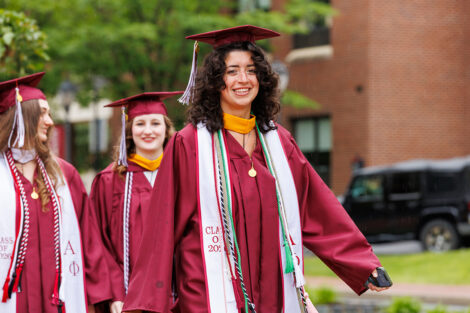 Graduates smile on their way to Commencement
