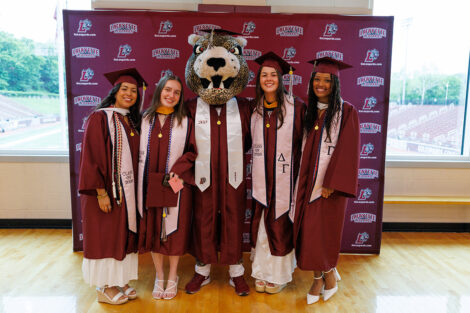 Graduates smile with the Leopard.