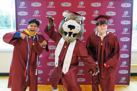 Graduates smile with the Leopard.