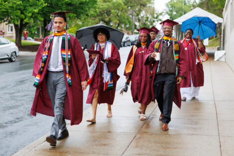 Graduates smile on their way to Commencement