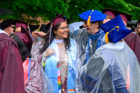 A professor hugs a student.