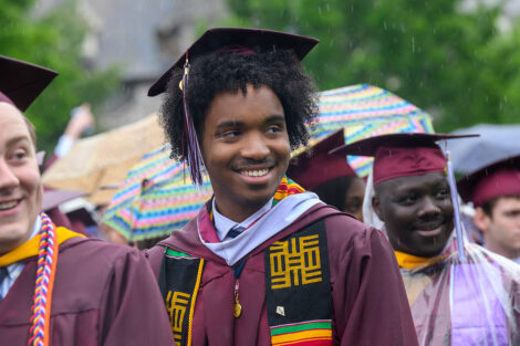 A student smiles in the rain.