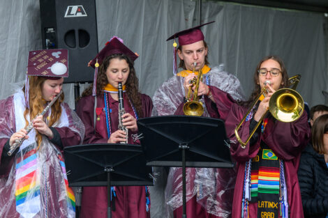 Graduates perform with the band, playing instruments during Commencement.