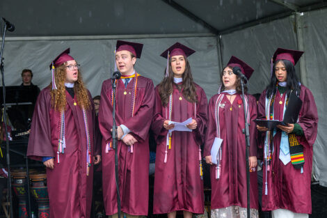 Graduates sing during commencement.