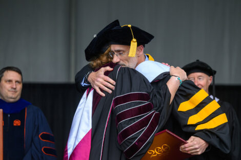 Arthur C. Brooks hugs President Nicole Hurd.