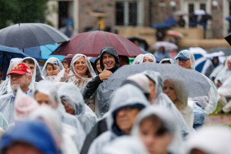 Family members smile in ponchos in the crowd.
