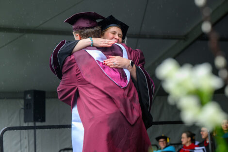 A graduate hugs President Nicole Hurd