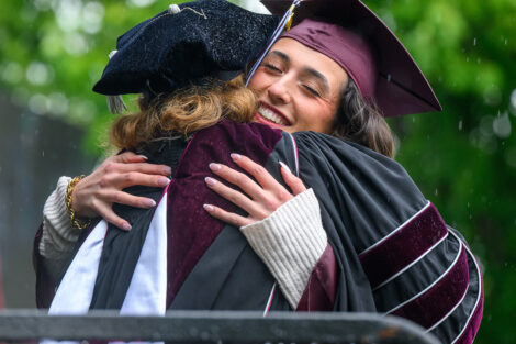 A graduate hugs President Nicole Hurd