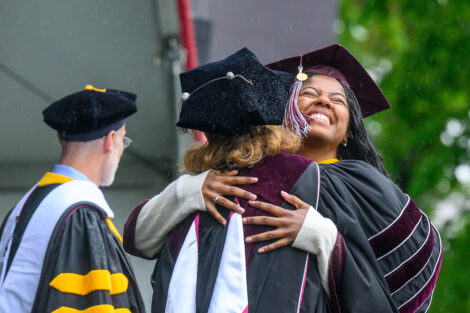 A graduate hugs President Nicole Hurd