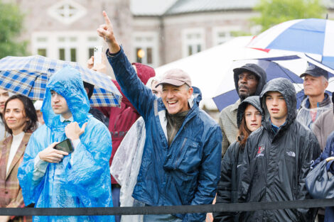 A member of the crowd takes pictures and cheers.