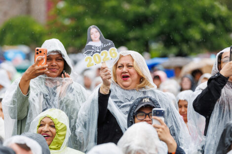 A member of the crowd takes pictures and cheers.
