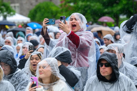A member of the crowd takes pictures and cheers.