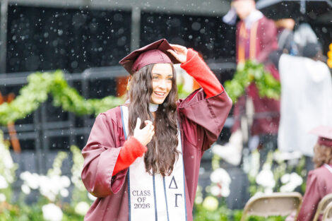 A graduate smiles between the raindrops.