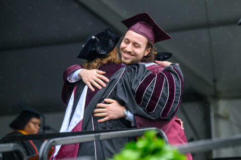 A graduate hugs President Nicole Hurd.