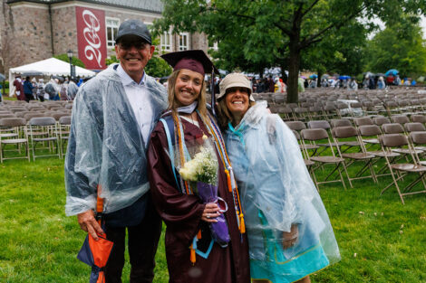 A graduate smiles with their family.