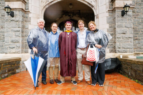 A graduate smiles with their family.
