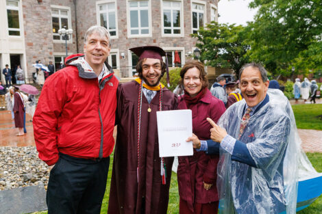 A graduate smiles with their family.