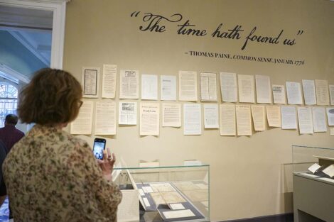 A guest stands in front of a wall that says 