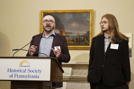 Prof. Chris Phillips stands with a student at the podium