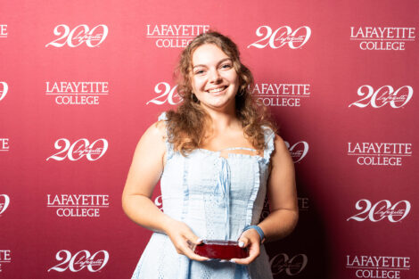 Abigail Feeley ’28 s holding a glass award.