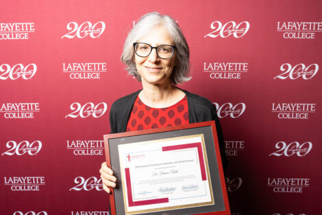 Bianca Falbo is holding a framed award.
