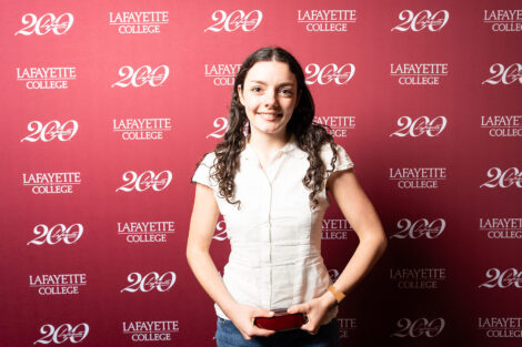 Charlotte Carter ’26 is holding a glass award.
