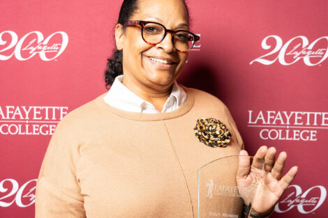 Chris Stewart is smiling at the camera and holding an award.