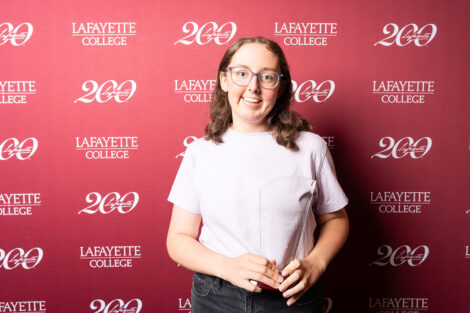 Emma Serpi ’28 is holding a glass award